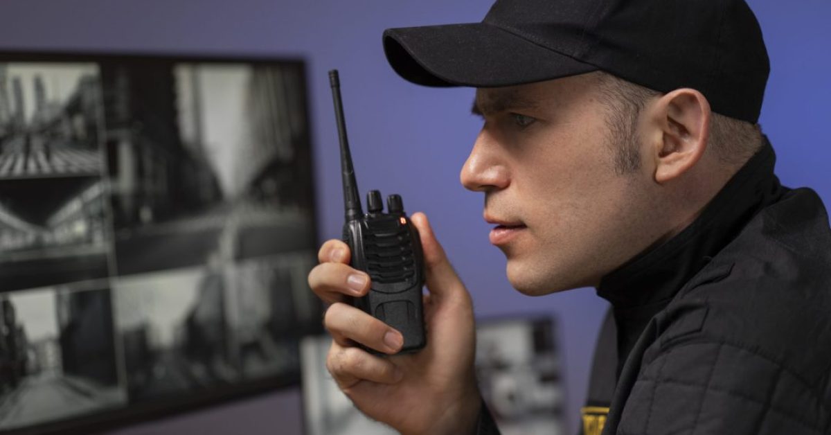 retrato-do-guarda-de-seguranca-masculino-com-estacao-de-radio-e-telas-de-camera retrato-do-guarda-de-seguranca-masculino-com-estacao-de-radio-e-telas-de-camera